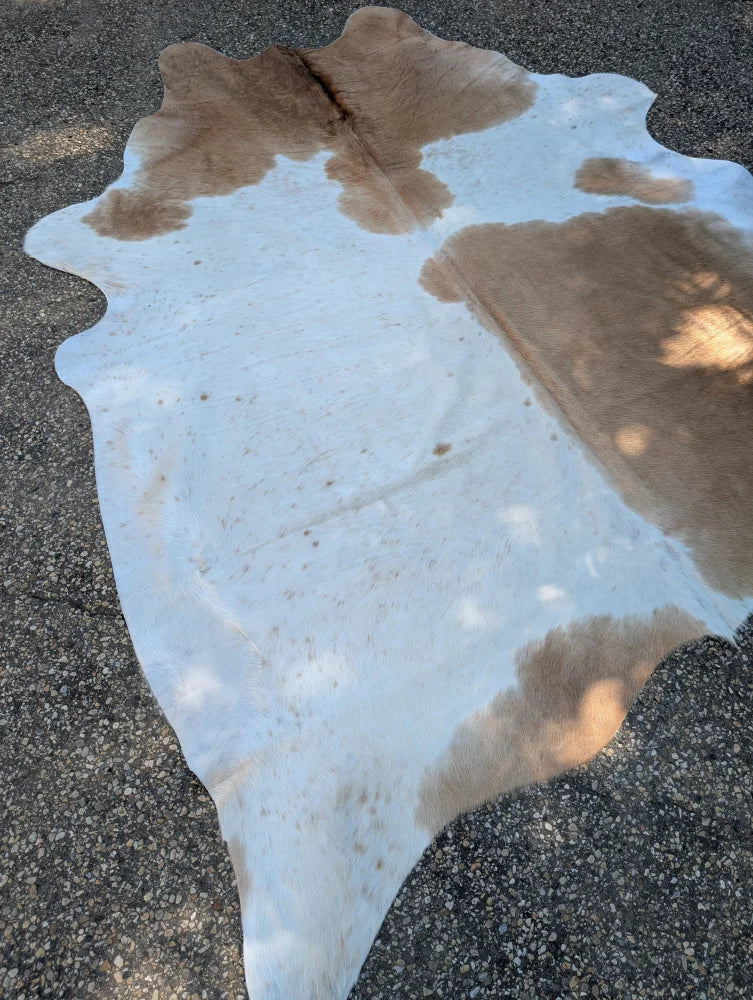 Beigewhite large cowhide rug with white and tan spotted pattern and rustic charm featuring irregular edges