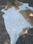 Beigewhite large cowhide rug with white and tan spotted pattern and rustic charm featuring irregular edges