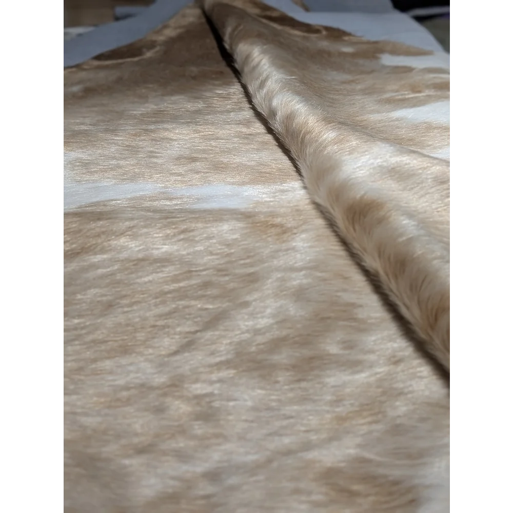 Extra large cowhide rug in beige and brown textured fabric with subtle shimmer