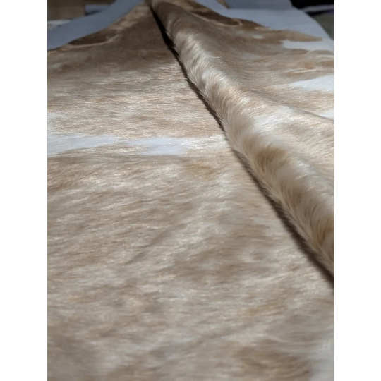 Extra large cowhide rug in beige and brown textured fabric with subtle shimmer