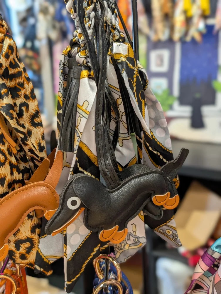 Black dachshund bag charm in real leather with orange accents
