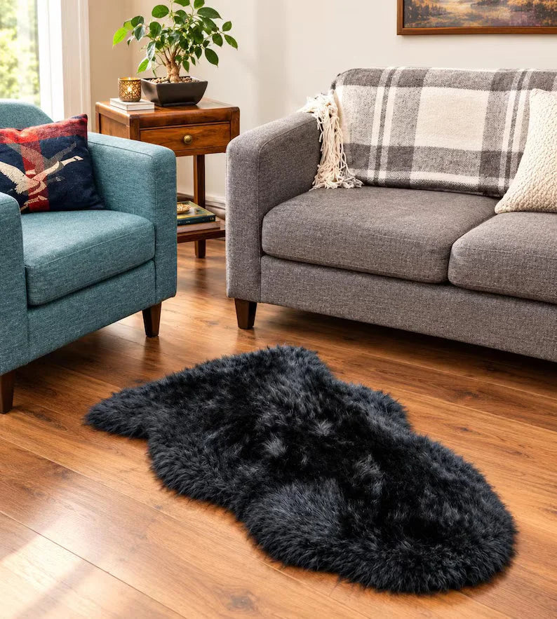Black merino sheepskin rug with plush shaggy texture and irregular organic shape perfect for cozy spaces
