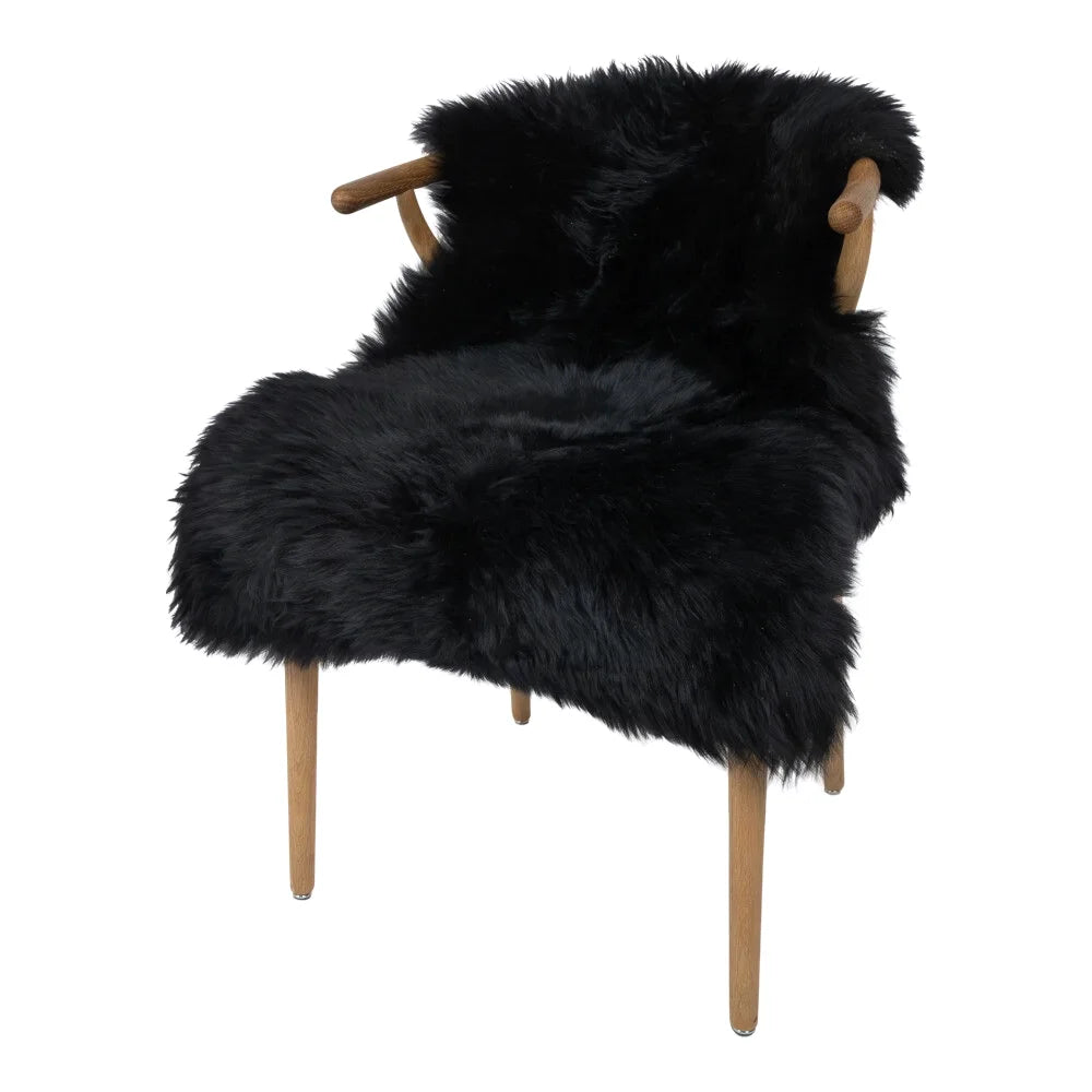 Black merino sheepskin armchair with dyed merino sheepskins cover and light wood frame meeting european standards