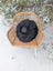 Black rotund sheepskin cushion with black faux fur and smooth dark center accent perfect for rotund sheep cushions
