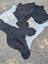 Large black and white cowhide rug 85.5 x 77 with natural fur texture and unique rustic charm