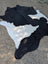 Large black and white cowhide rug with natural fur texture showcasing unique characteristics and rustic charm