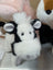 A plush black and white cow toy with fluffy fur soft ears and a rounded snout perfect for kids and decor