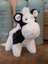 A plush black white cow toy with soft fluffy fur and a giant snuggly muzzle perfect for cuddling