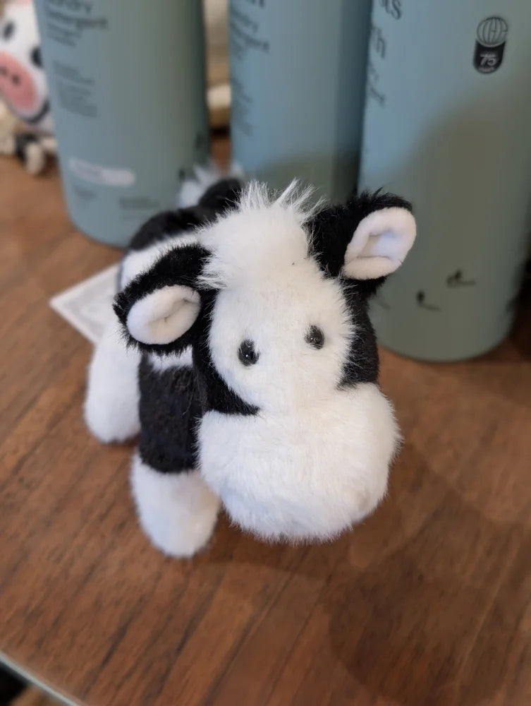 Adorable black white cow plush toy with soft fluffy fur and a giant snuggly muzzle perfect for cuddling
