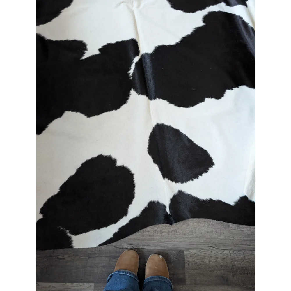 Black and white large cowhide rug with a plush textured surface perfect for beautiful rugs by angus oliver