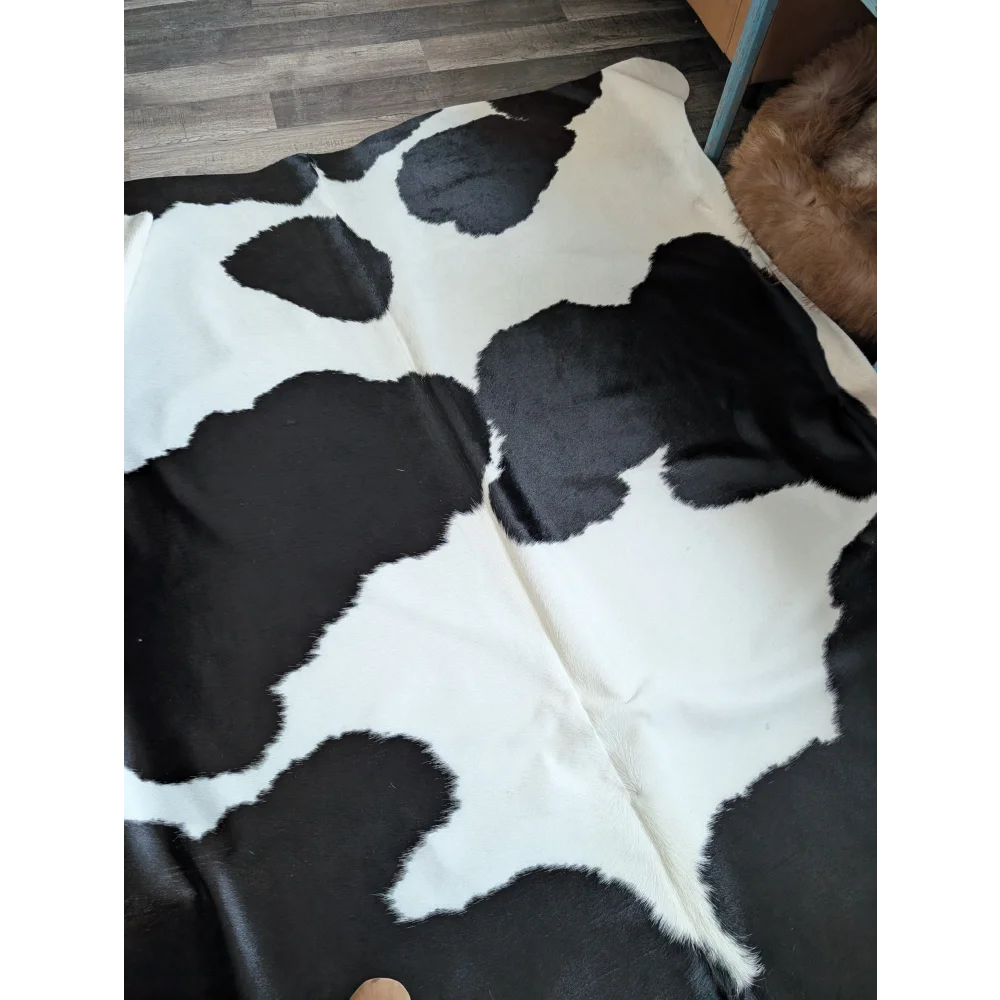 Black and white large cowhide rug with natural fluffy texture from angus oliver beautiful rugs collection