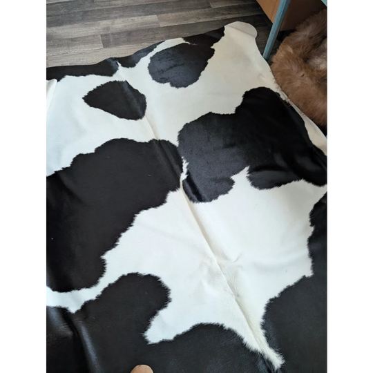 Black and white large cowhide rug with natural fluffy texture from angus oliver beautiful rugs collection