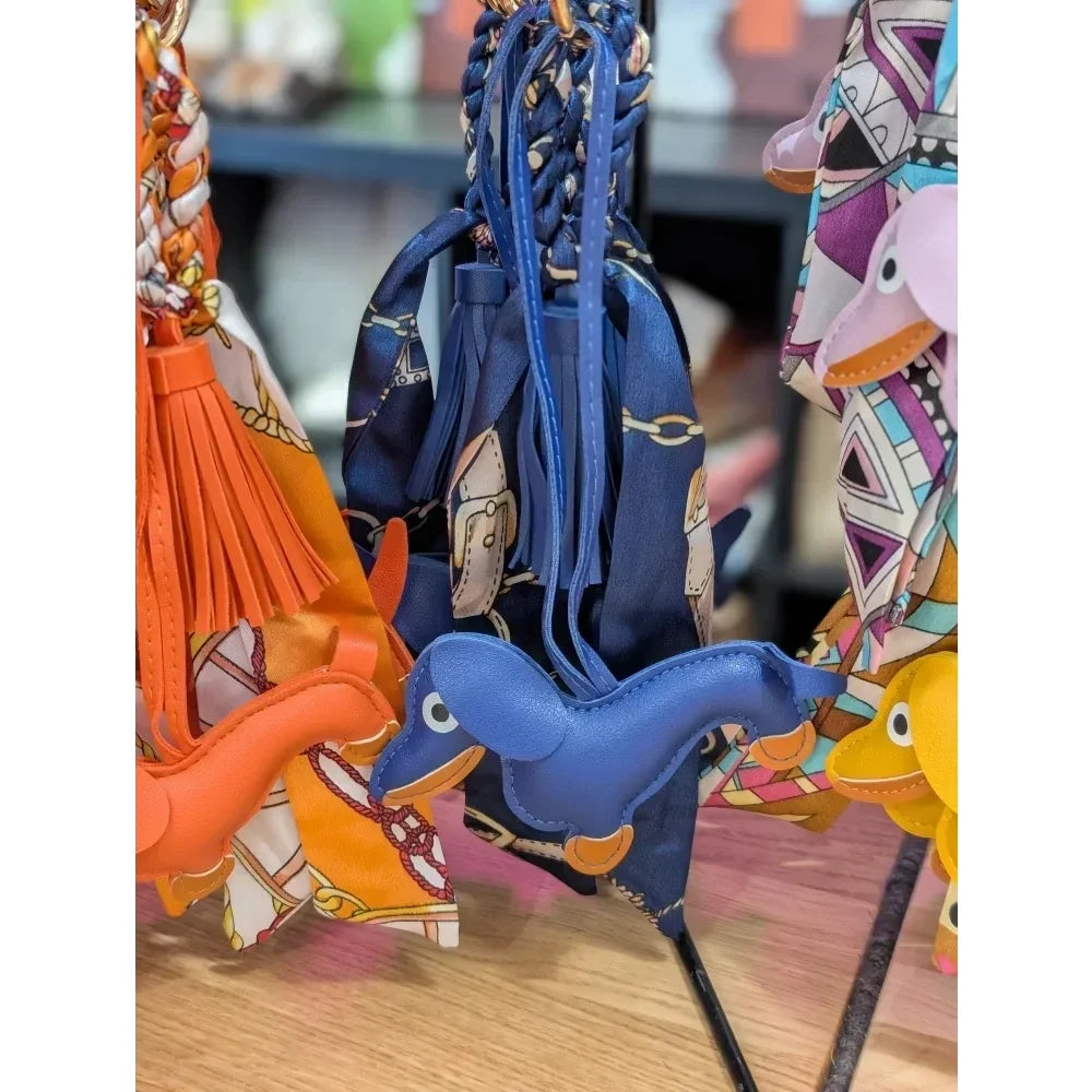 Blue leather dinosaur keychain with orange accents from angus oliver bag charm featuring real cowhide rugs vibe