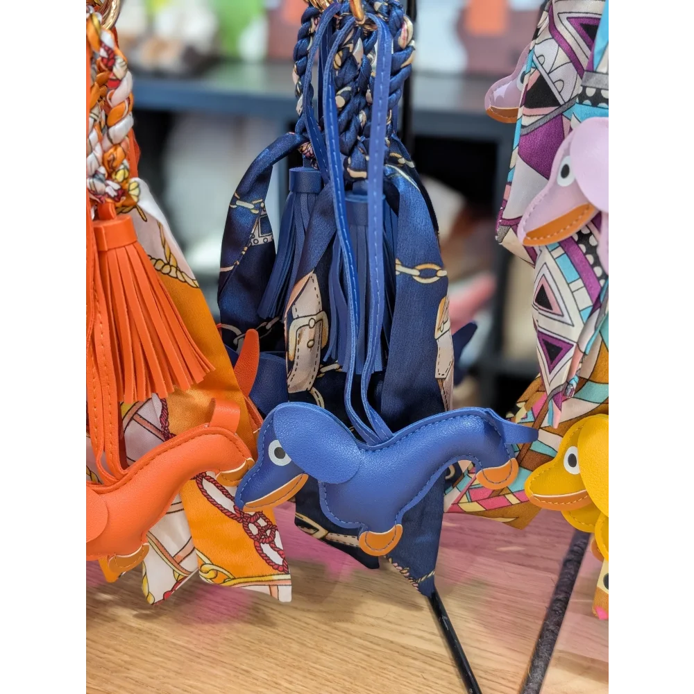 Blue dachshund bag charm with leather dinosaur and orange accents