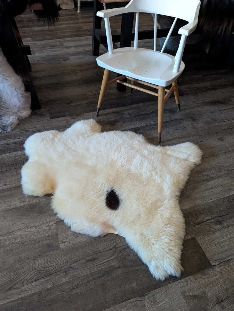 Cream-colored fluffy bear-shaped sheepskin rug with black nose made from british isles sheepskin brit12 model