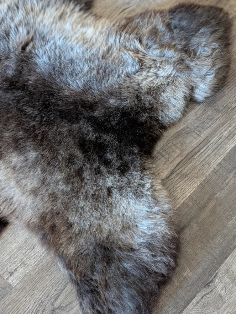 A plush naturally textured brit#13 british isles sheepskin rug in mottled dark brown gray and beige fur