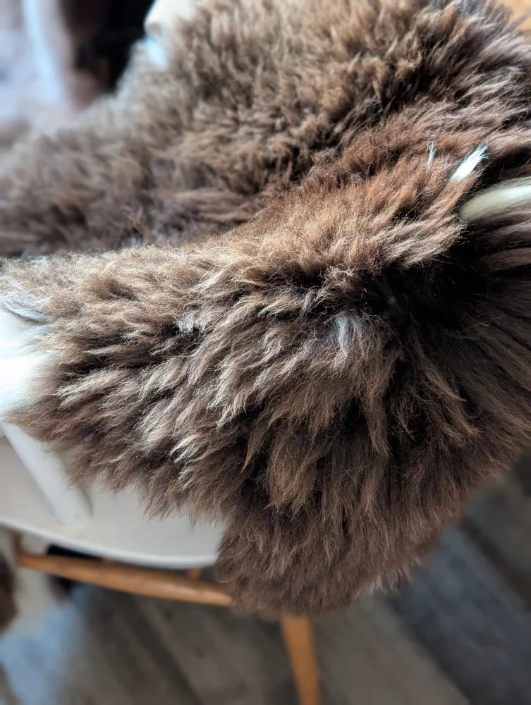 A plush brown british isles sheepskin throw with soft fluffy texture and natural shade variations