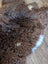A plush curly brown british isles sheepskin rug with soft white patches perfect for cozy home decor