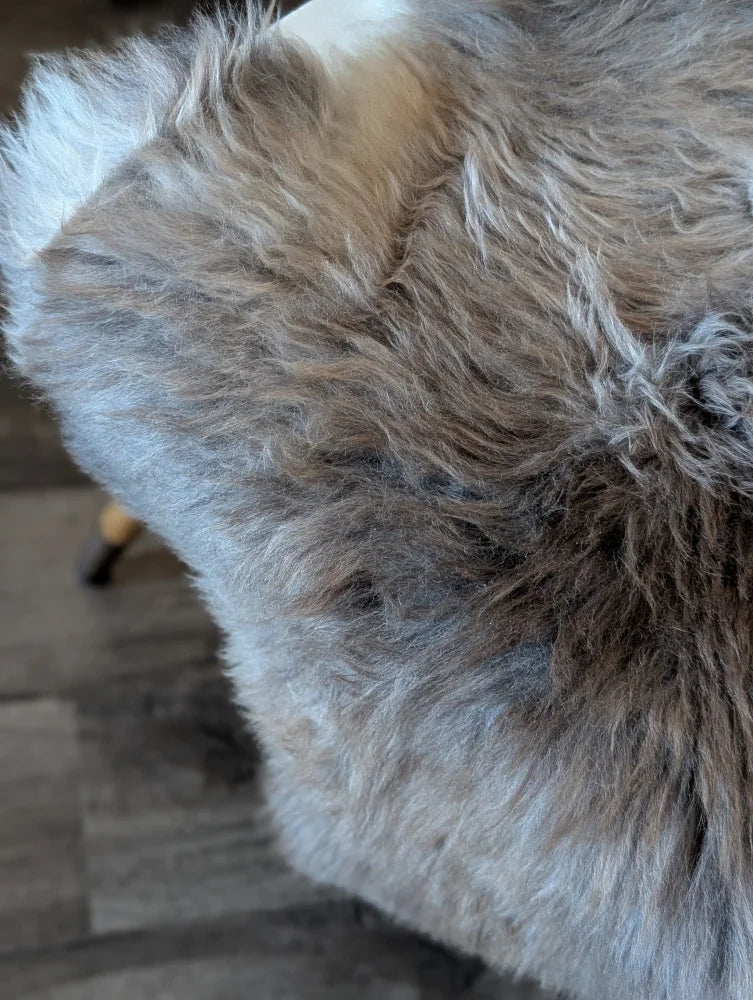 A plush shaggy gray british isles sheepskin throw blanket with a soft textured surface perfect for cozy use
