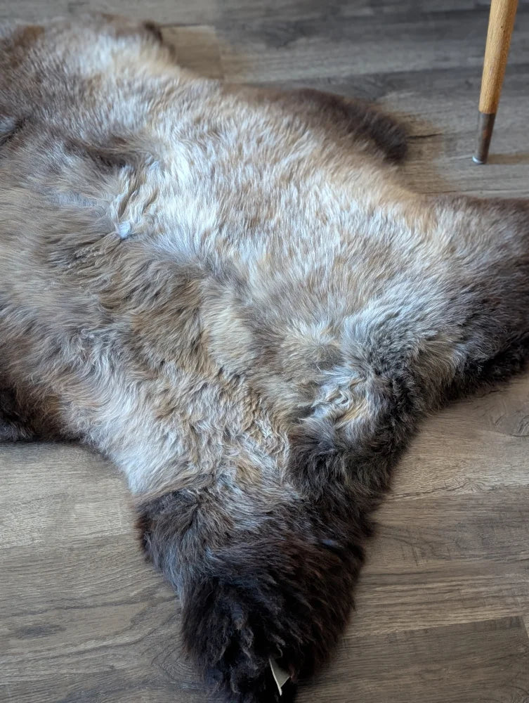 A plush british isles sheepskin rug with natural brown and gray tones measuring 47 by 29 inches