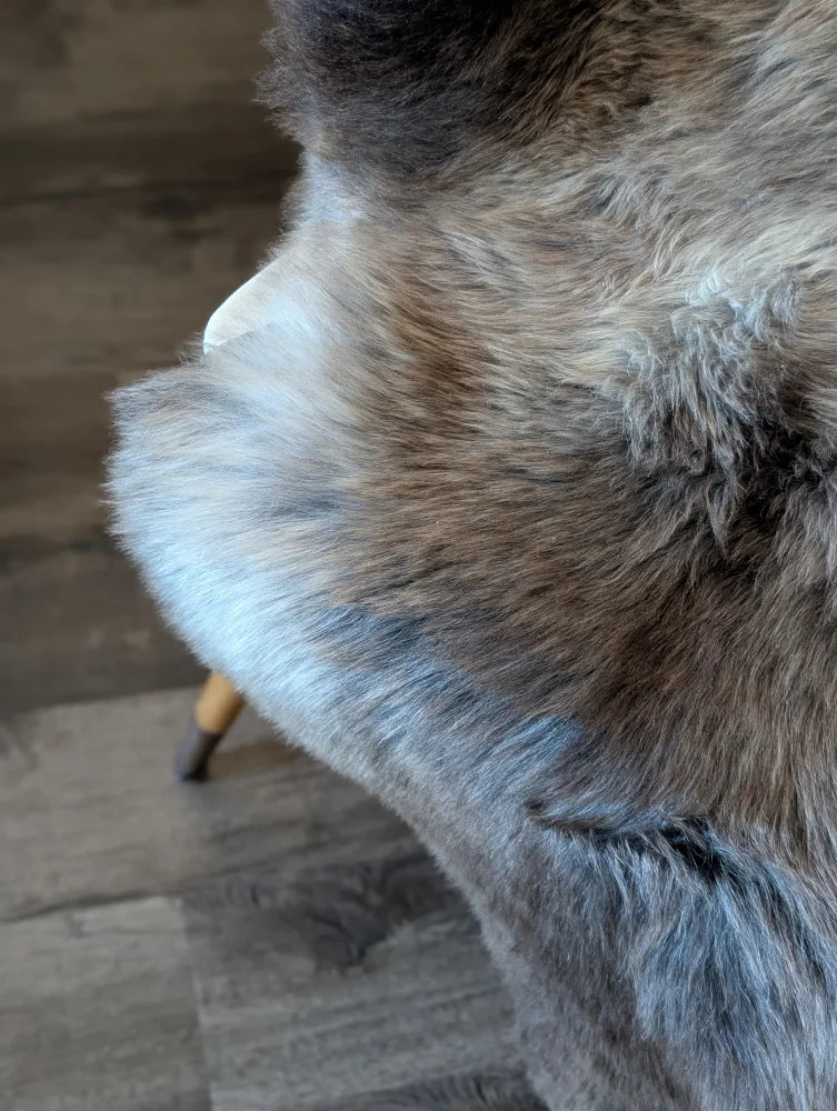 A plush british isles sheepskin throw in gray brown and white faux fur with soft gradient texture measuring 47 by 29 inches