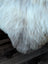 A soft fluffy white and gray faux fur british isles sheepskin blanket with a natural mottled texture, 48 by 30 inches
