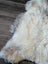 Cream-colored fluffy british isles sheepskin rug with natural fur texture and soft mottled tones 48 x 30 inches