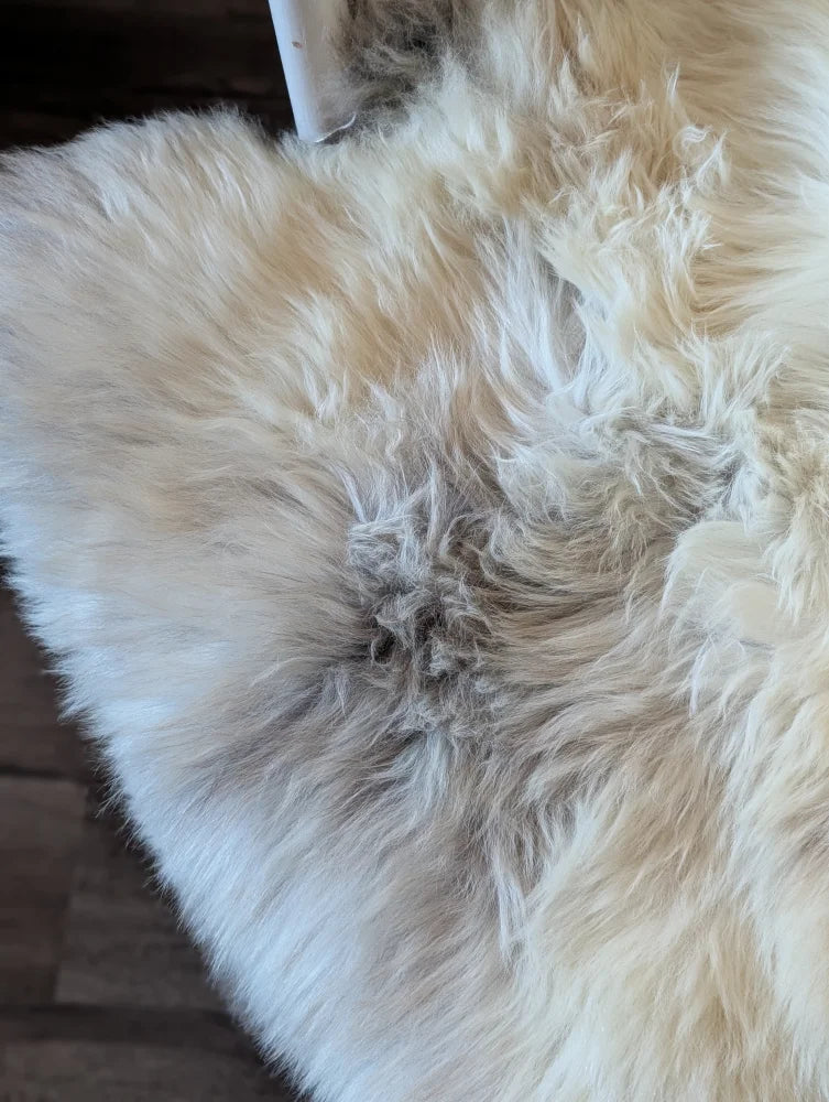 Cream-colored fluffy british isles sheepskin rug with soft natural texture and subtle grayish patches brit17 48x30