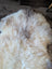 Cream-colored fluffy british isles sheepskin rug with natural tone and texture variations 48 x 30 inches