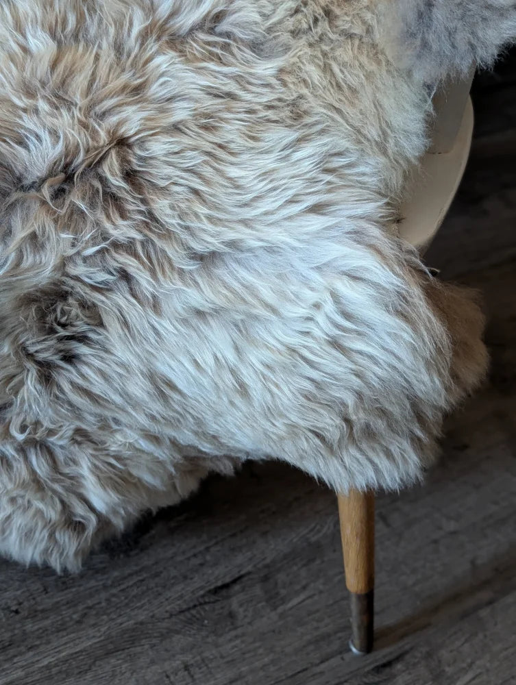 Fluffy naturally textured british isles sheepskin rug in cream and light brown tones for cozy home decor
