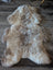 A natural-toned fluffy british isles sheepskin rug with irregular edges lies flat perfect for cozy decor