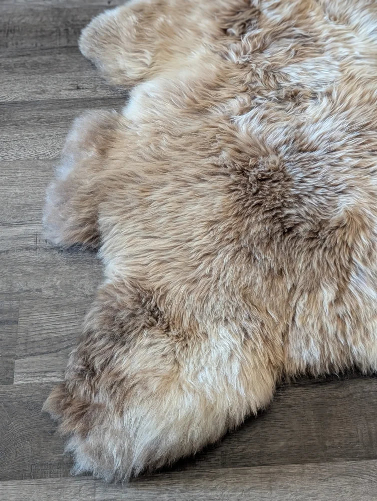 A natural-toned british isles sheepskin rug with soft fluffy texture and irregular edges in 48 by 33 inches