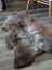 A plush natural brown and gray british isles sheepskin rug with thick soft fur texture measuring 49 by 29 inches