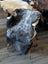 A plush dark gray british isles sheepskin rug with soft fluffy texture and natural fur pattern, 47 by 31 inches