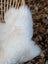 Brit#9 off-white very soft british isles sheepskin rug draped over woven wicker chair back with fluffy texture