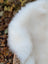 A plush white faux fur scarf with soft fluffy texture made from british isles sheepskin measuring 47 by 29 inches