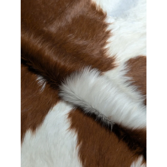 Fluffy brown and white faux fur scarf on extra large cowhide rug