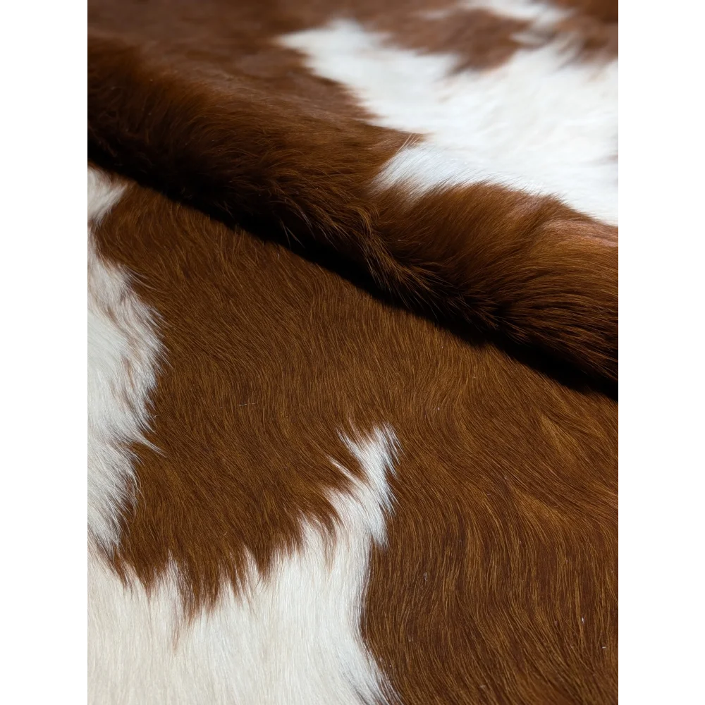 Extra large cowhide rug with brown and white patches, textured surface