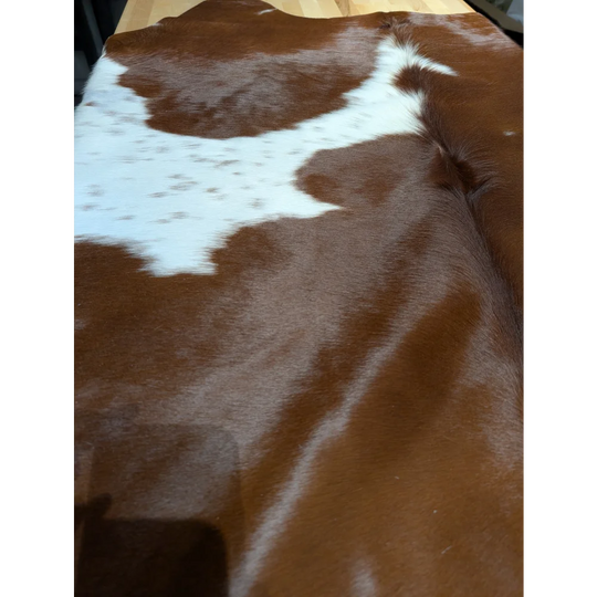 Extra large cowhide blanket with brown and white patches, soft underfoot texture