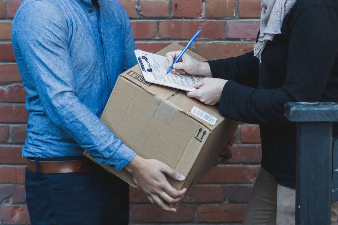 Brown cardboard shipping box with barcode and arrow symbols