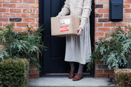 A brown cardboard box with red and white shipping labels.