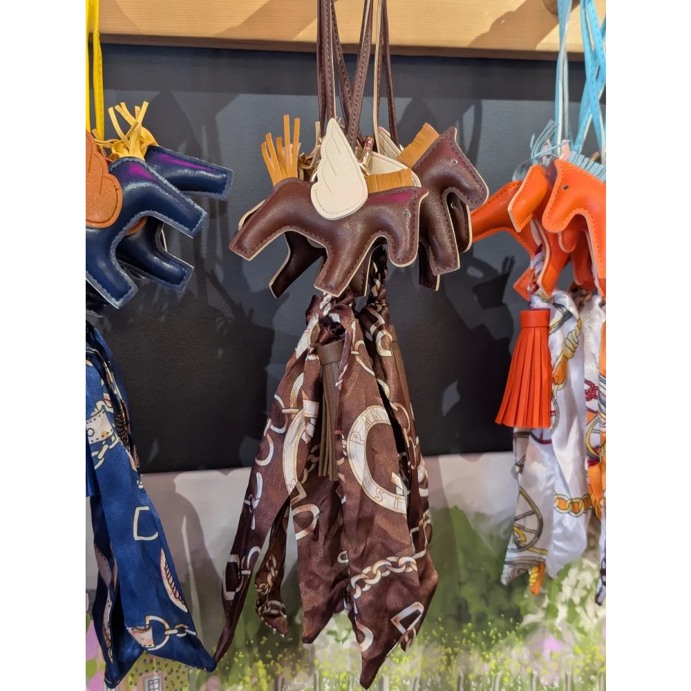 Brown horse bag charm with tassel, white wings and printed scarf