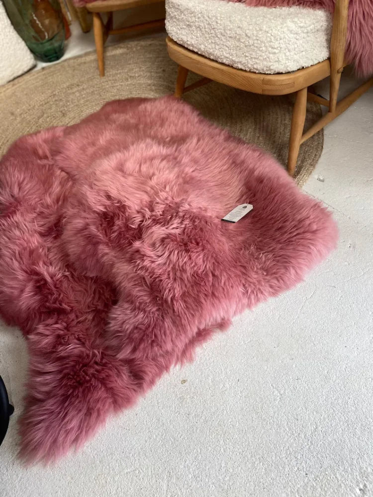 A plush dusty pink merino sheepskin rug with a soft fluffy texture and natural irregular shape arriving soon