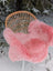 Pink merino sheepskin faux fur chair cover draped over wicker chair arriving mid october