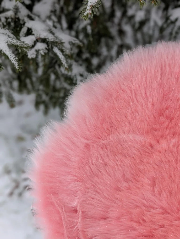 A plush soft pink merino sheepskin throw blanket with fluffy texture and subtle shimmer arriving mid october