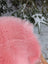A soft plush pink merino sheepskin throw blanket draped over a wicker chair arriving mid october