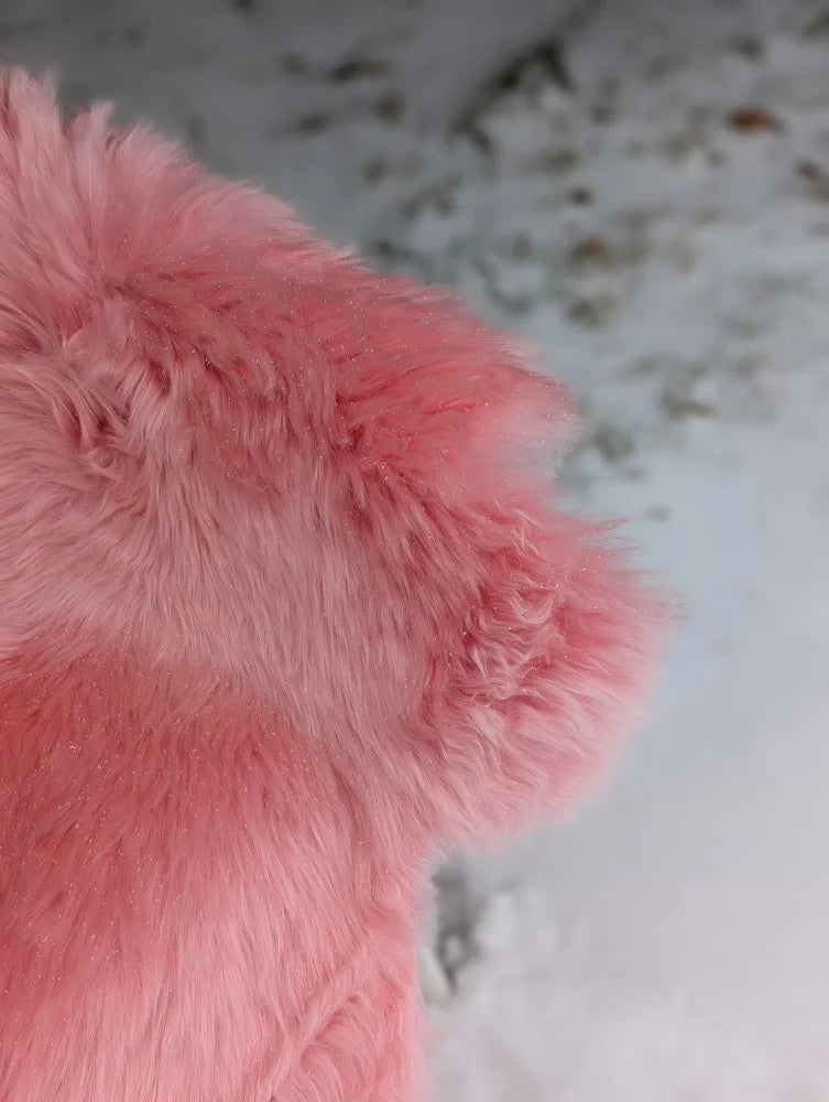 A soft fluffy pink merino sheepskin plush toy with a fuzzy textured surface that meets reach standards