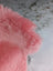 A soft fluffy pink merino sheepskin plush toy with a fuzzy textured surface that meets reach standards