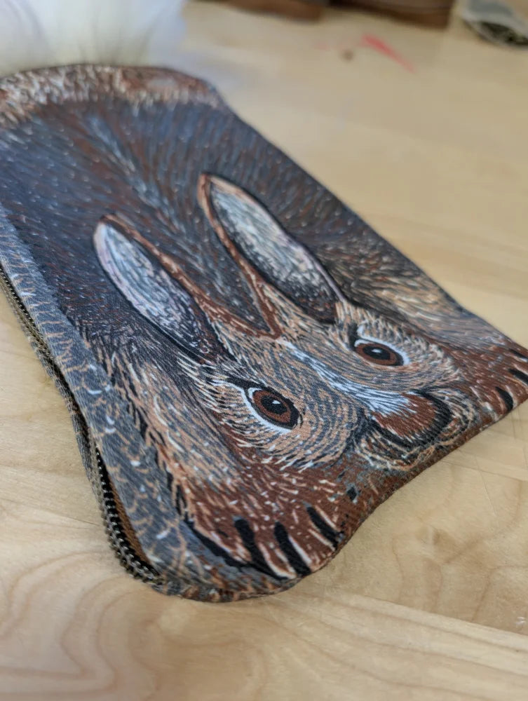 Brown leather coin purse with sheepskin tail featuring a hand-painted hare and textured fur details