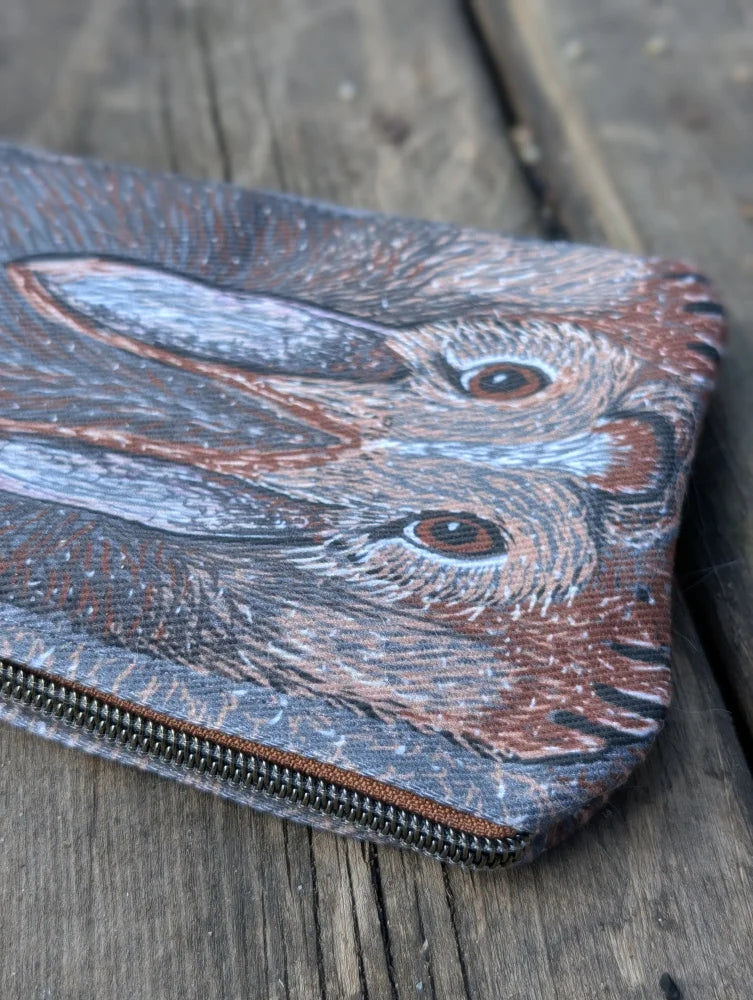 A cotton canvas bunny coin purse with sheepskin tail featuring two detailed brown and gray rabbits with expressive eyes